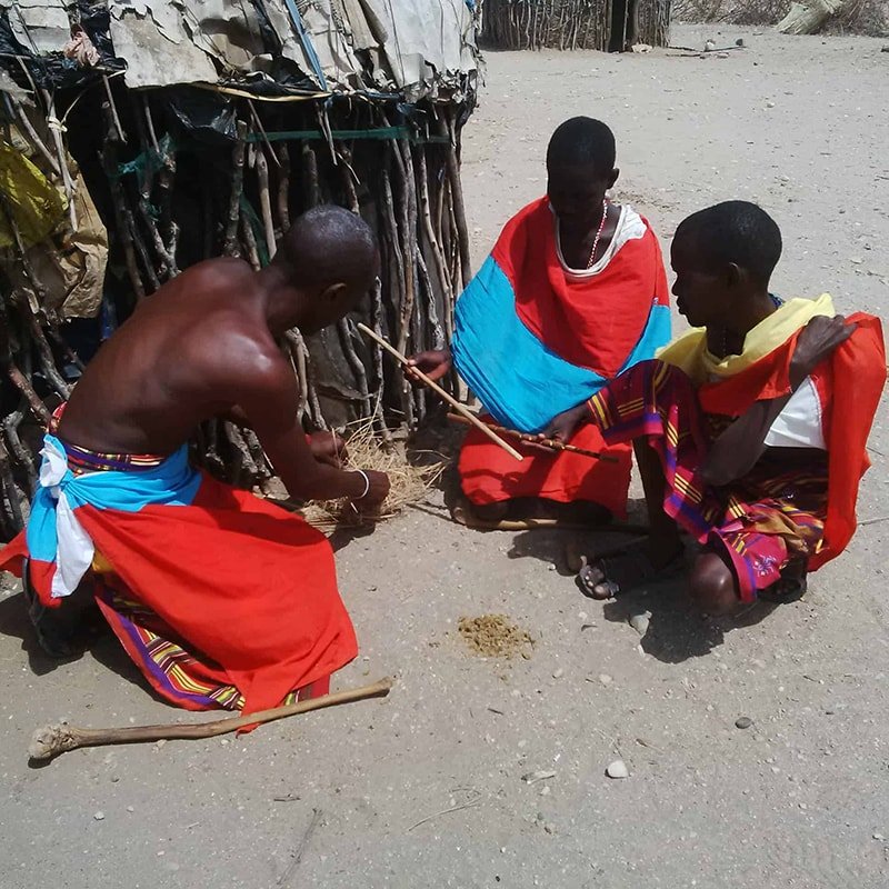 Samburu men lighting a fire using traditional methods, Archers Post, Kenya